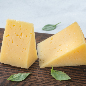 two wedges of white cheese on a cutting board