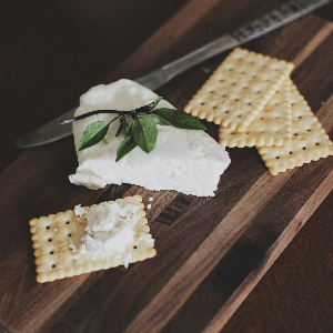 a wedge of goat cheese on a cutting board with crackers