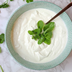 a bowl of yogurt with a mint leaf on top