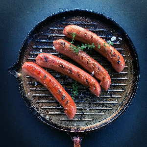 four sausages in a frying pan