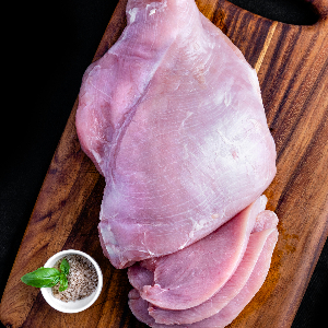 a raw turkey breast on a cutting board