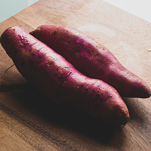 two sweet potatoes on a cutting board