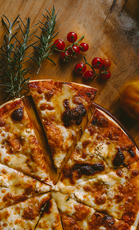 pizza on a wooden table cut into triangular slices